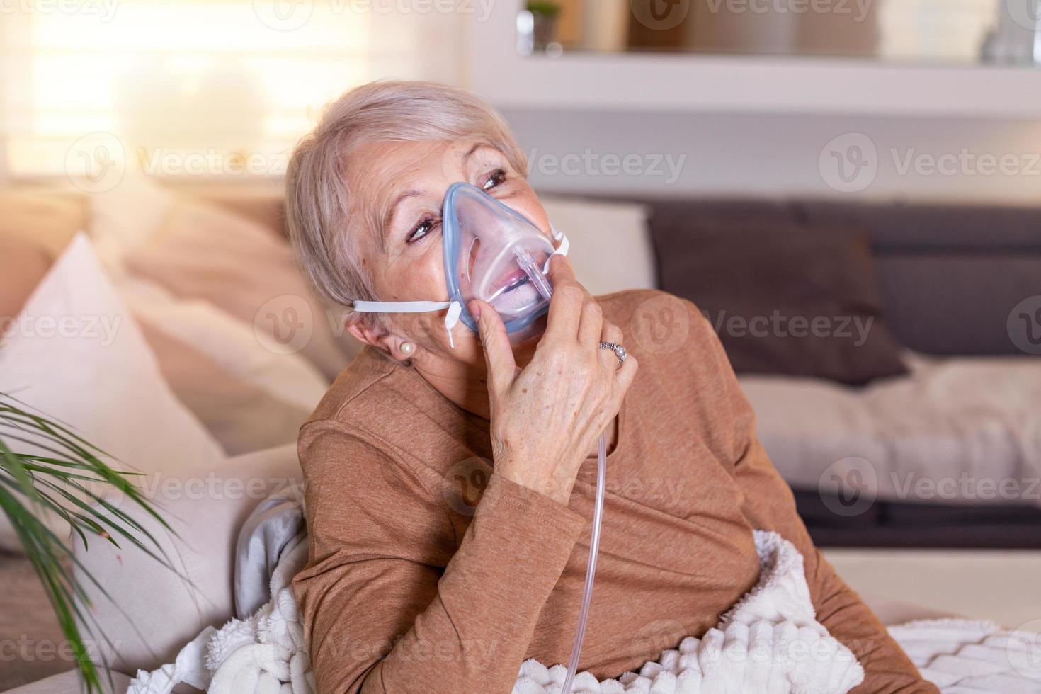 Sick elderly woman making inhalation, medicine is the best medicine. Ill senior woman wearing an oxygen mask and undergoing treatment. Senior woman with an inhaler photo