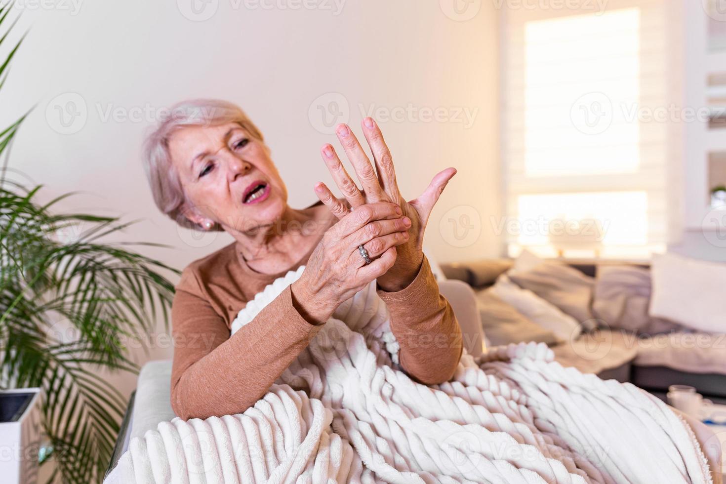 Elderly woman suffering from pain in hand, arthritis old person and senior woman female suffering from pain at home photo