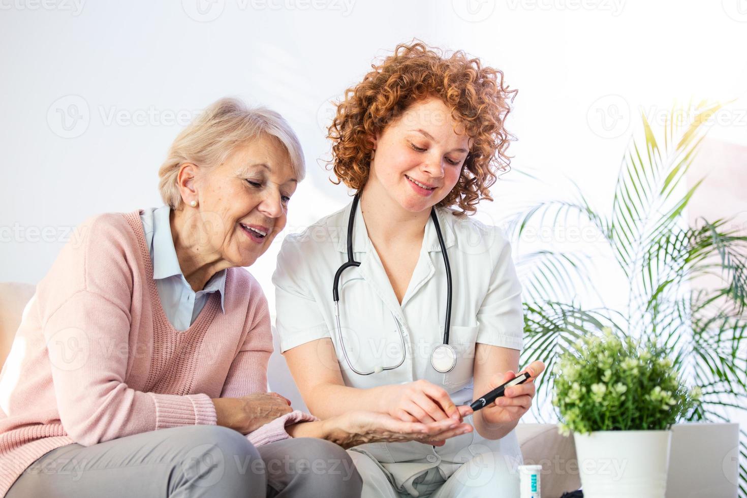 Caregiver measuring blood sugar of senior woman at home. Kind carer measuring the blood sugar of a happy elderly woman in bed in the nursing home. Diabetes and glicemia concept photo