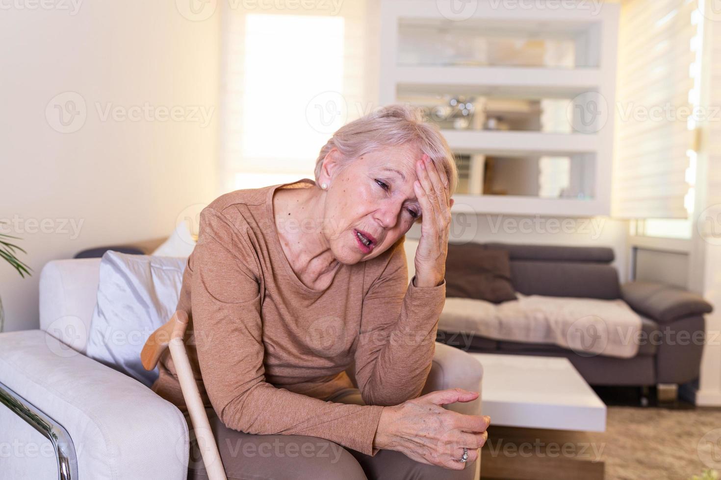 ataque del monstruo migraña. dolor de sinusitis. infeliz anciana jubilada sosteniendo su cabeza con expresión de dolor. cara de anciana que sufre de dolor de cabeza foto
