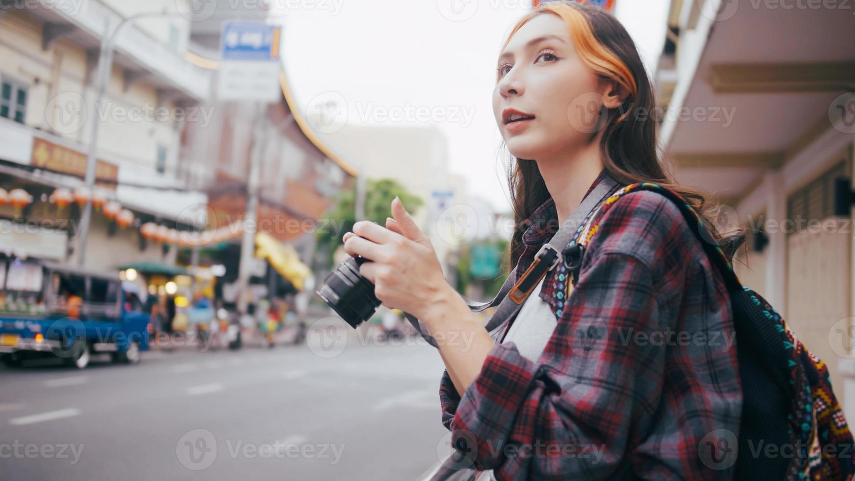 A beautiful woman tourist enjoys taking photos of the city view in Bangkok, Thailand.