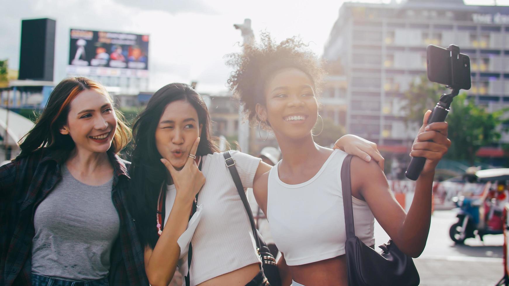 un grupo de amigas multiétnicas disfrutando del recorrido por la ciudad. jóvenes turistas divirtiéndose tomando fotos juntos.