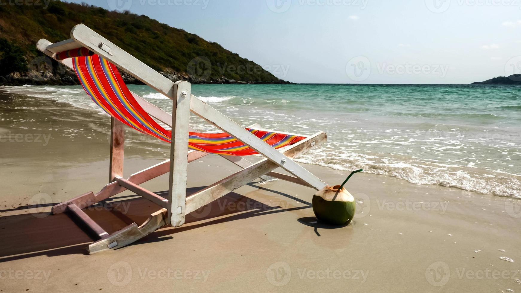 Colourful beach chair and peeled coconut on the beach. photo
