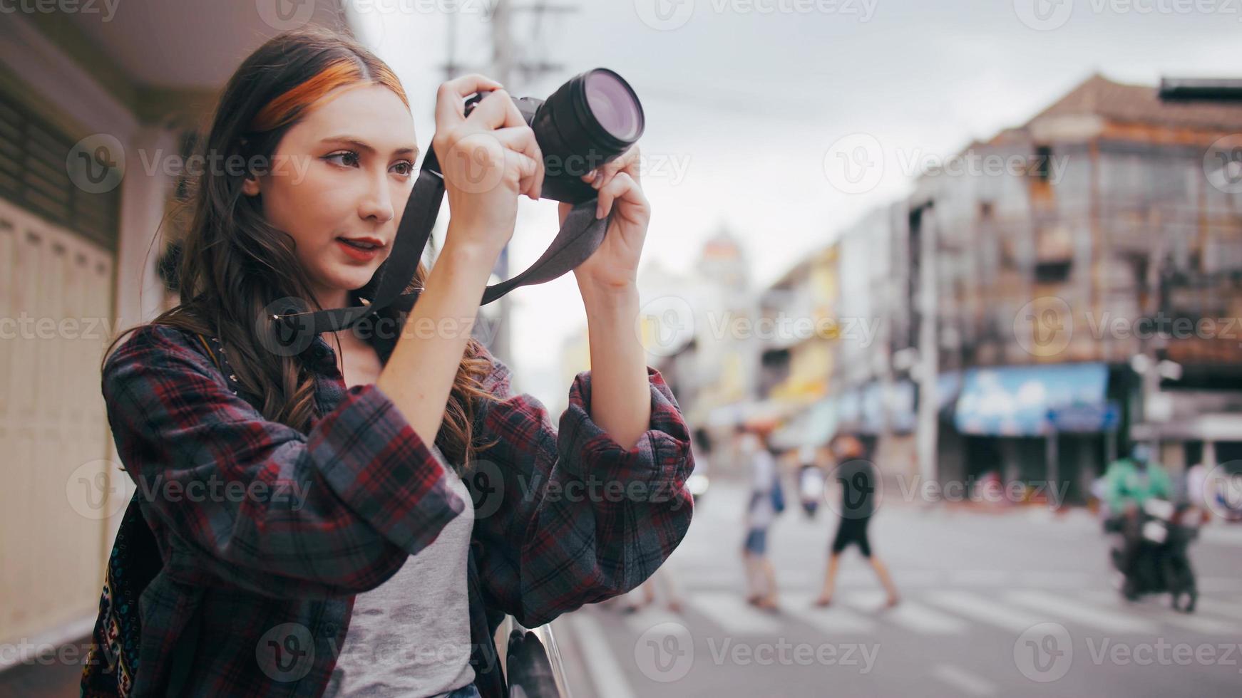 A beautiful woman tourist enjoys taking photos of the city view in Bangkok, Thailand.