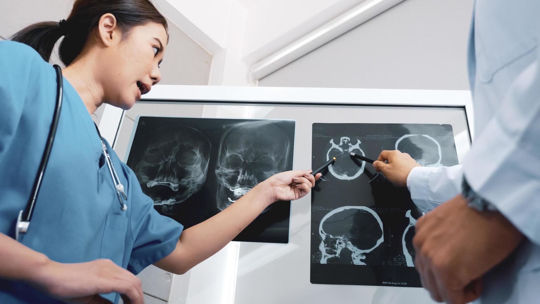 médico y asistentes médicos discutiendo sobre el resultado del diagnóstico en la película de rayos x. foto