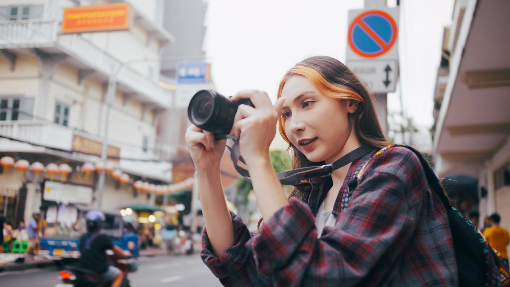 una hermosa mujer turista disfruta tomando fotos de la vista de la ciudad en bangkok, tailandia.