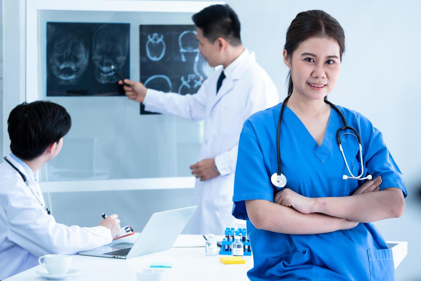 Doctor and medical assistants discussing about diagnosis result on x-ray film. photo