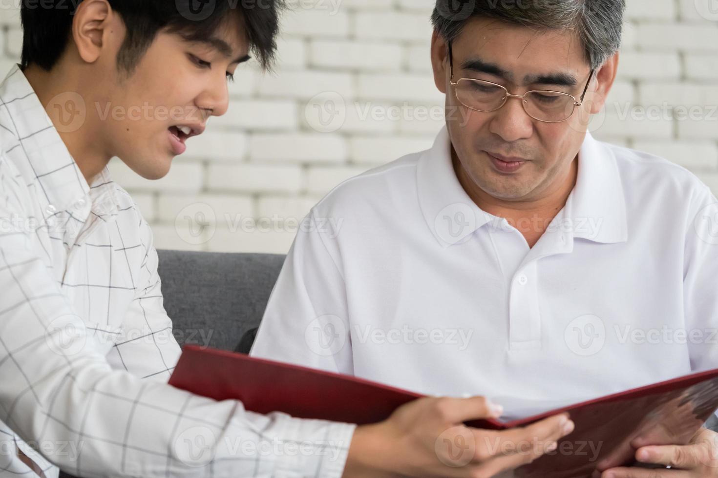 Young man agent recommending life insurance to senior man. photo