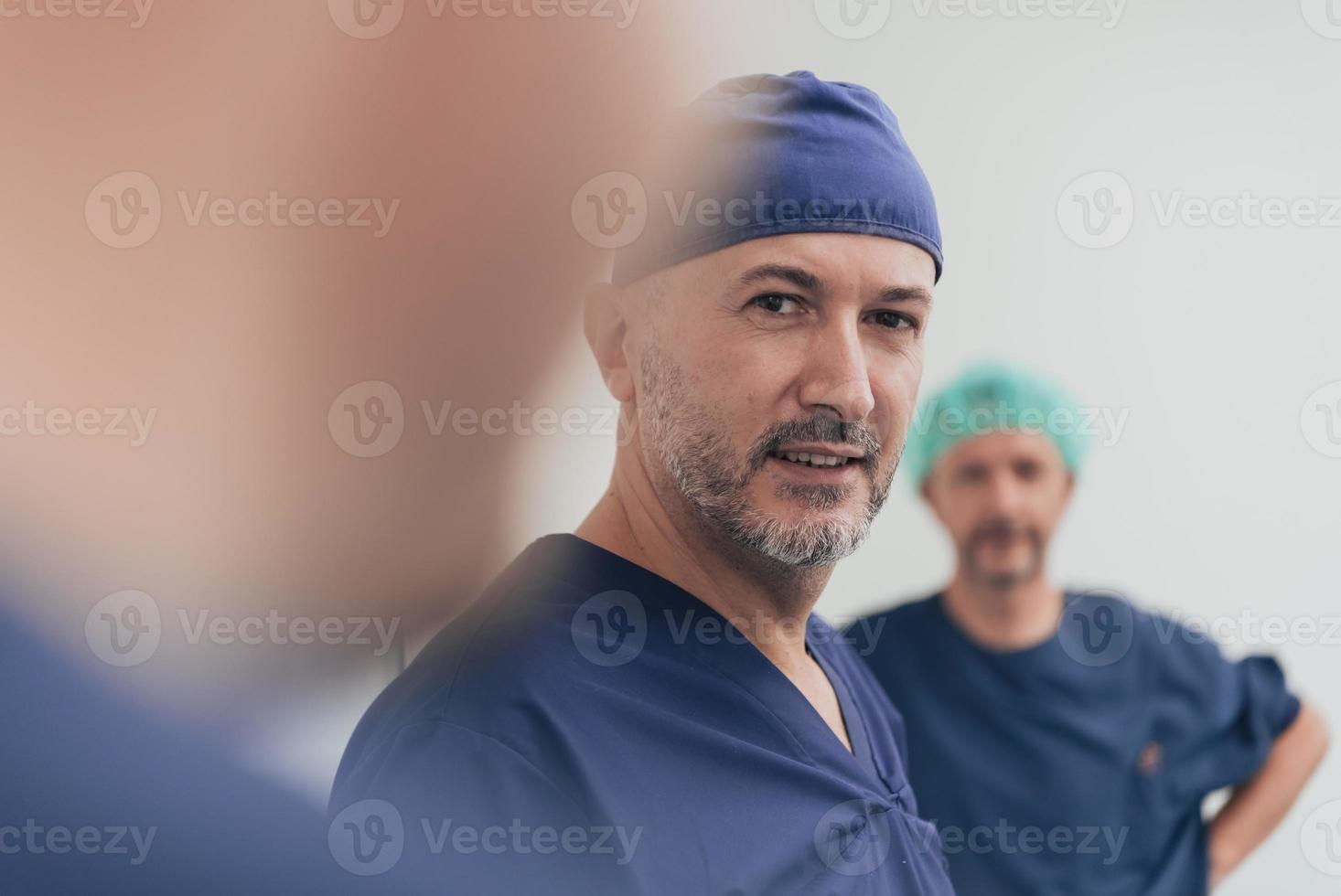 Multiethnic orthopedic doctor in front of his medical team looking at camera wearing face mask photo