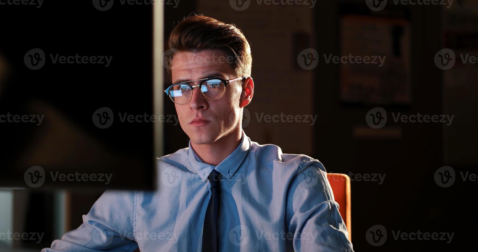 man working on computer in dark office photo