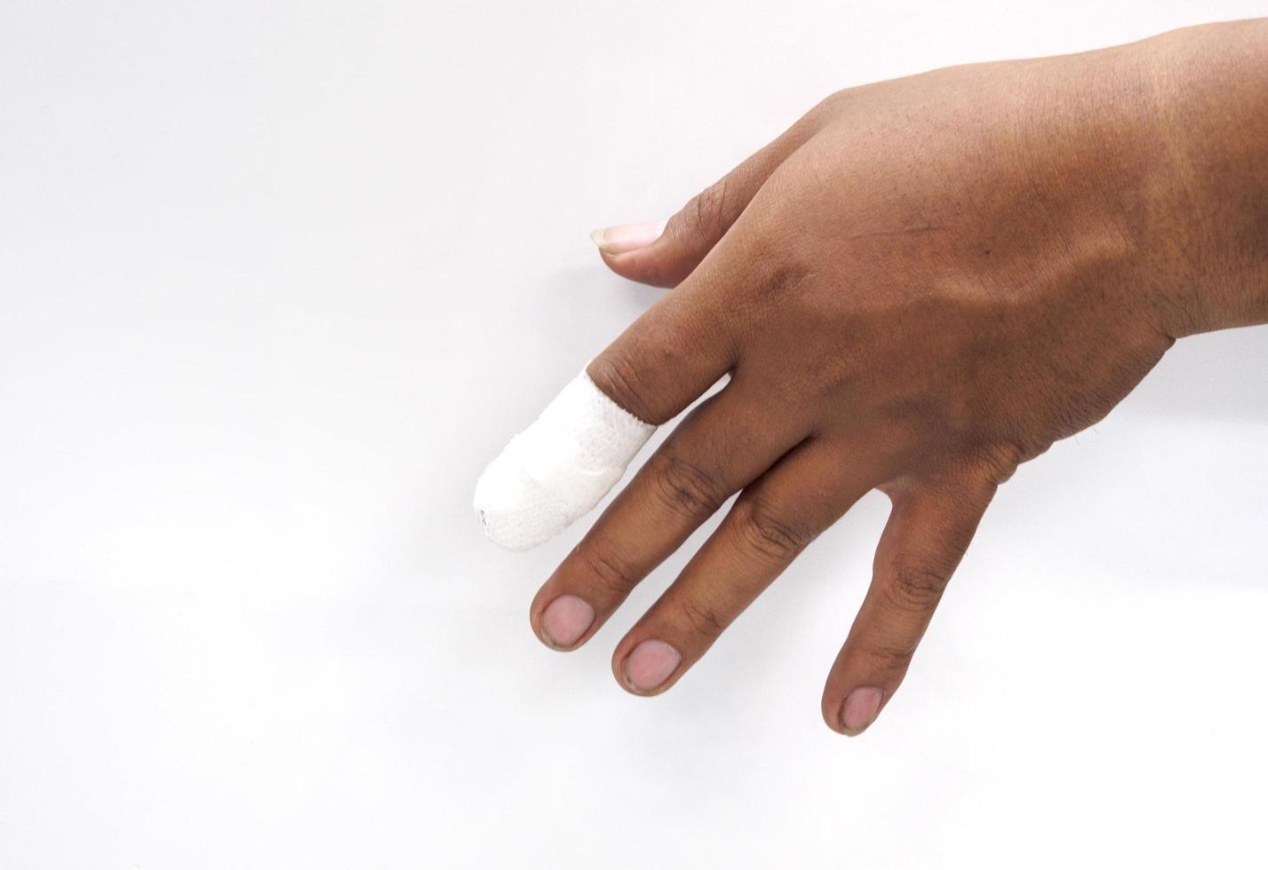 Hands close-up, Asian male craftsman in danger and injury to the left index finger from working in the industrial system with first aid with a bandage white hospital on a white background photo