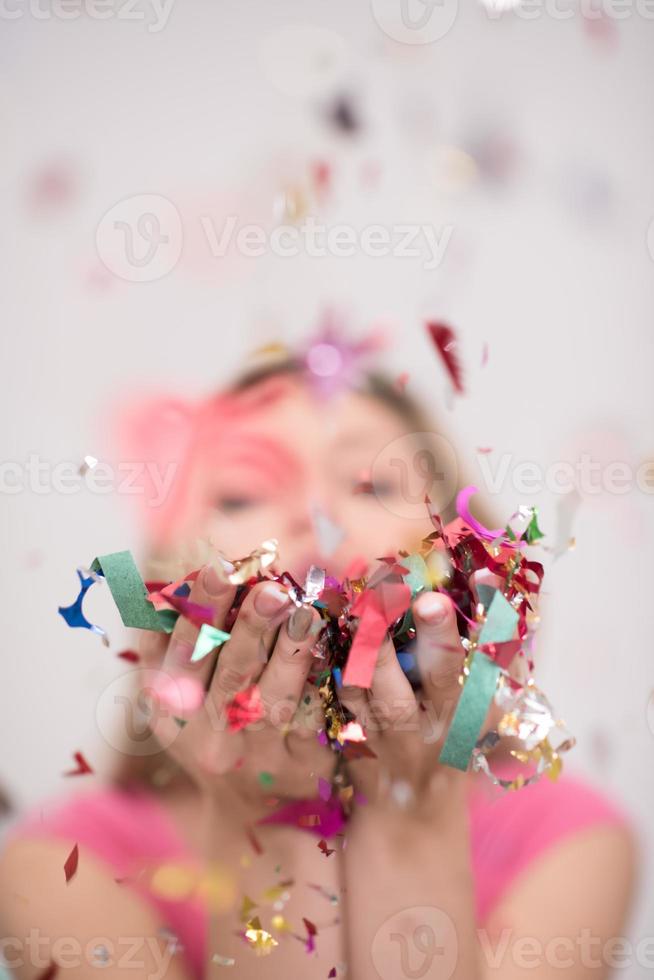 woman blowing confetti in the air photo