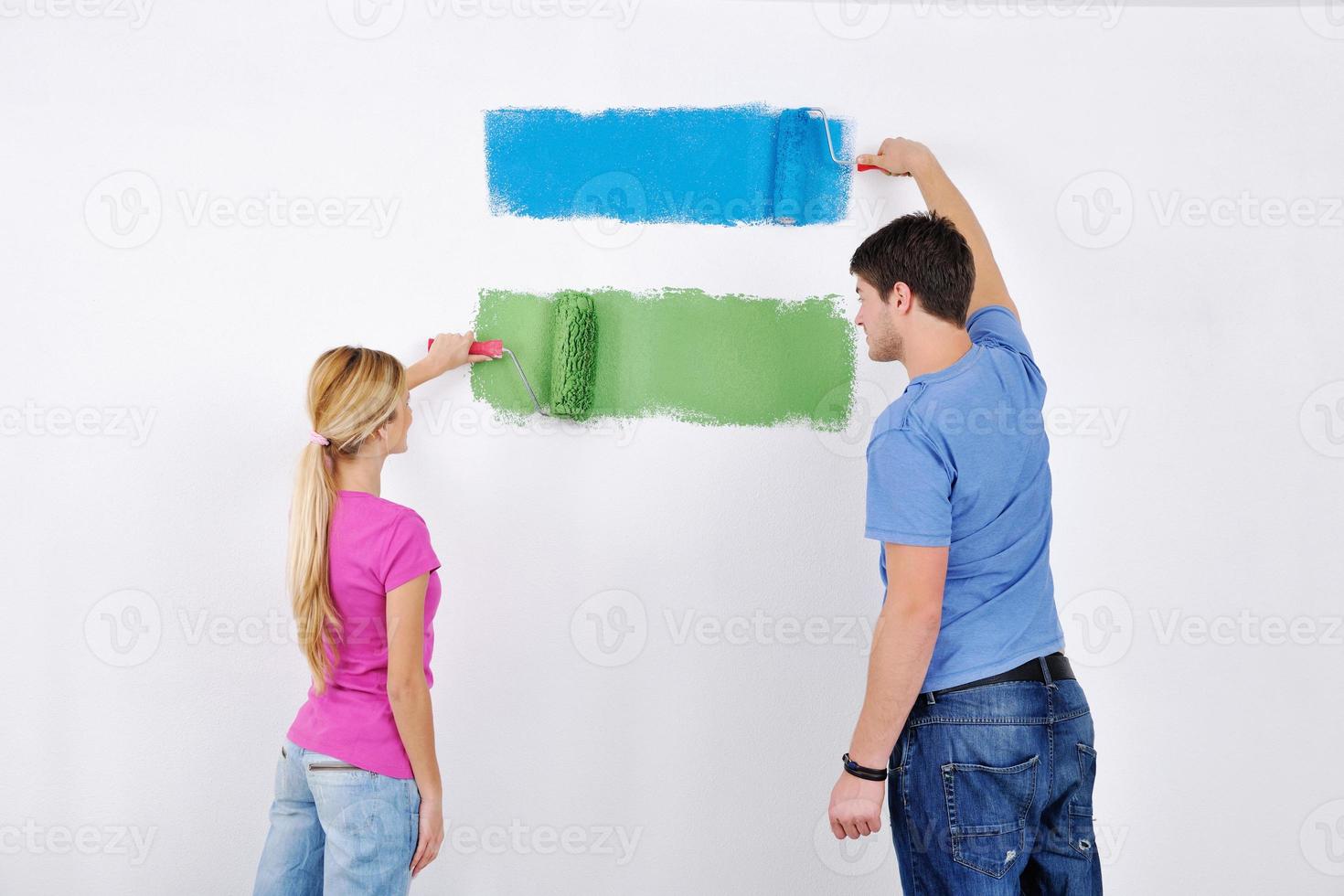 happy couple paint wall at new home photo