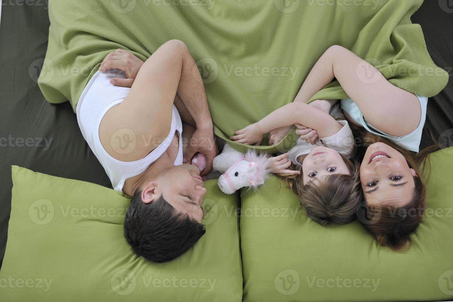 happy family relaxing in bed photo