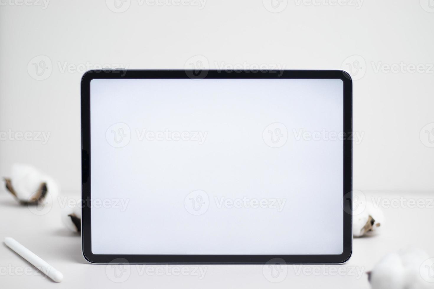 Tablet empty white screen with pencil and cotton flower on white background mockup for design photo