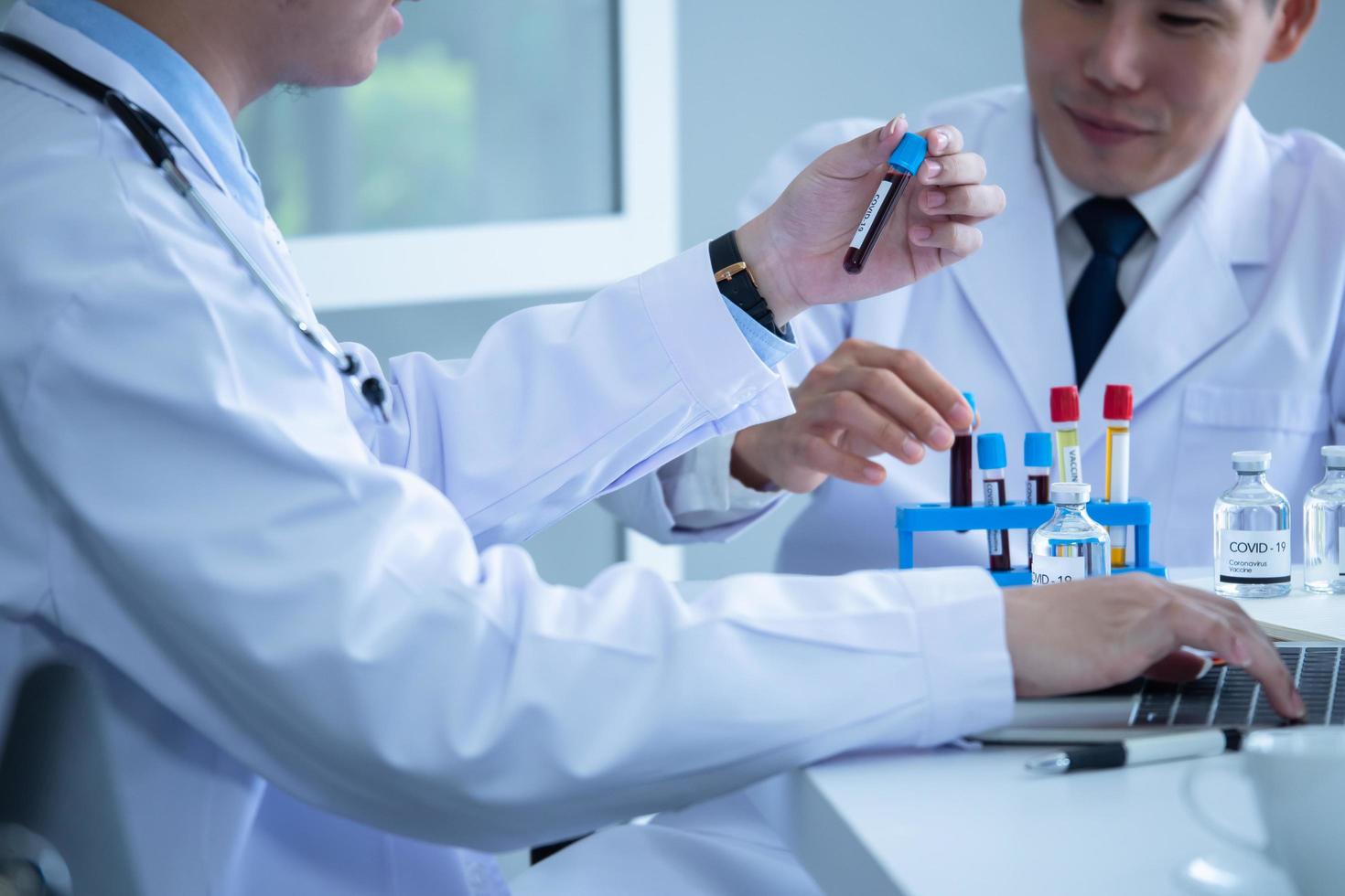 Scientist discussing with colleague about covid 19 vaccine in meeting room at hospital photo