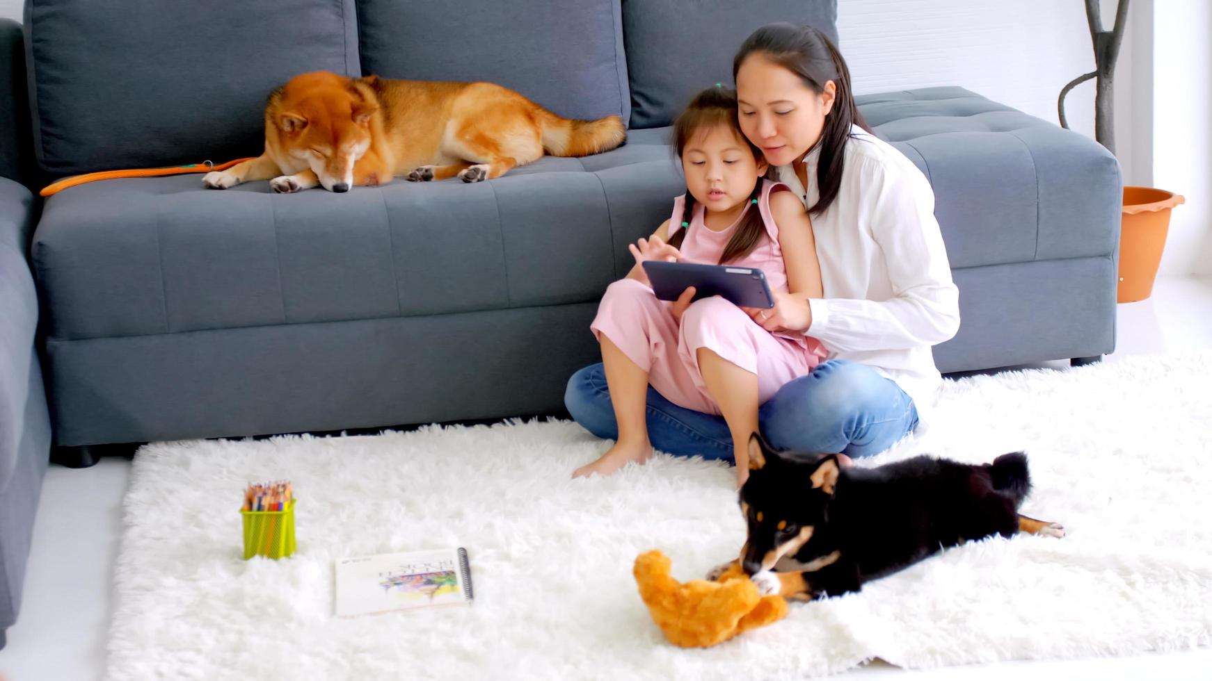 Mother and little daughter with their dog spending time together at home. photo