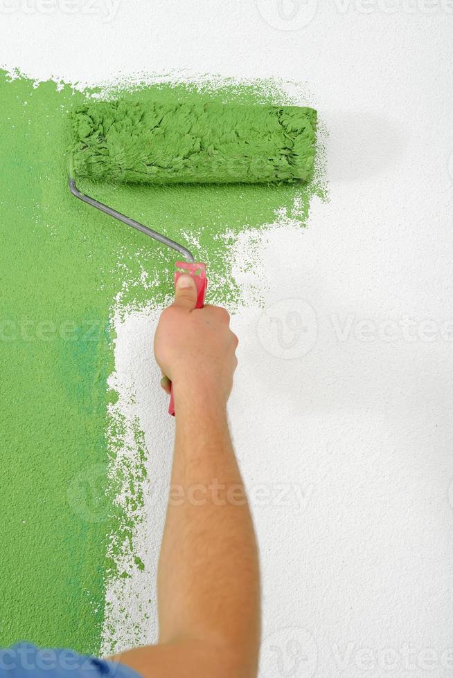 handsome young man paint white wall in color photo