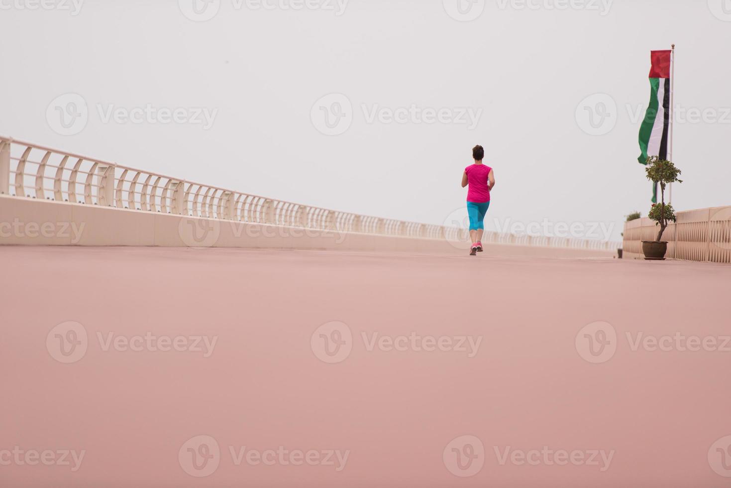 woman busy running on the promenade photo