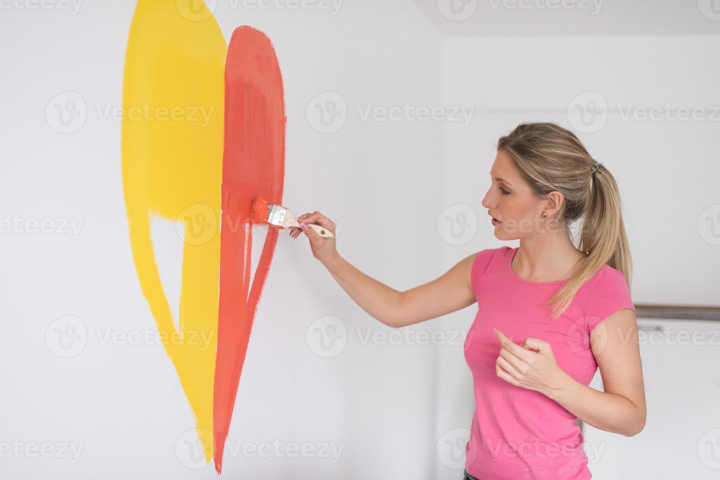 woman painting a heart on the wall photo