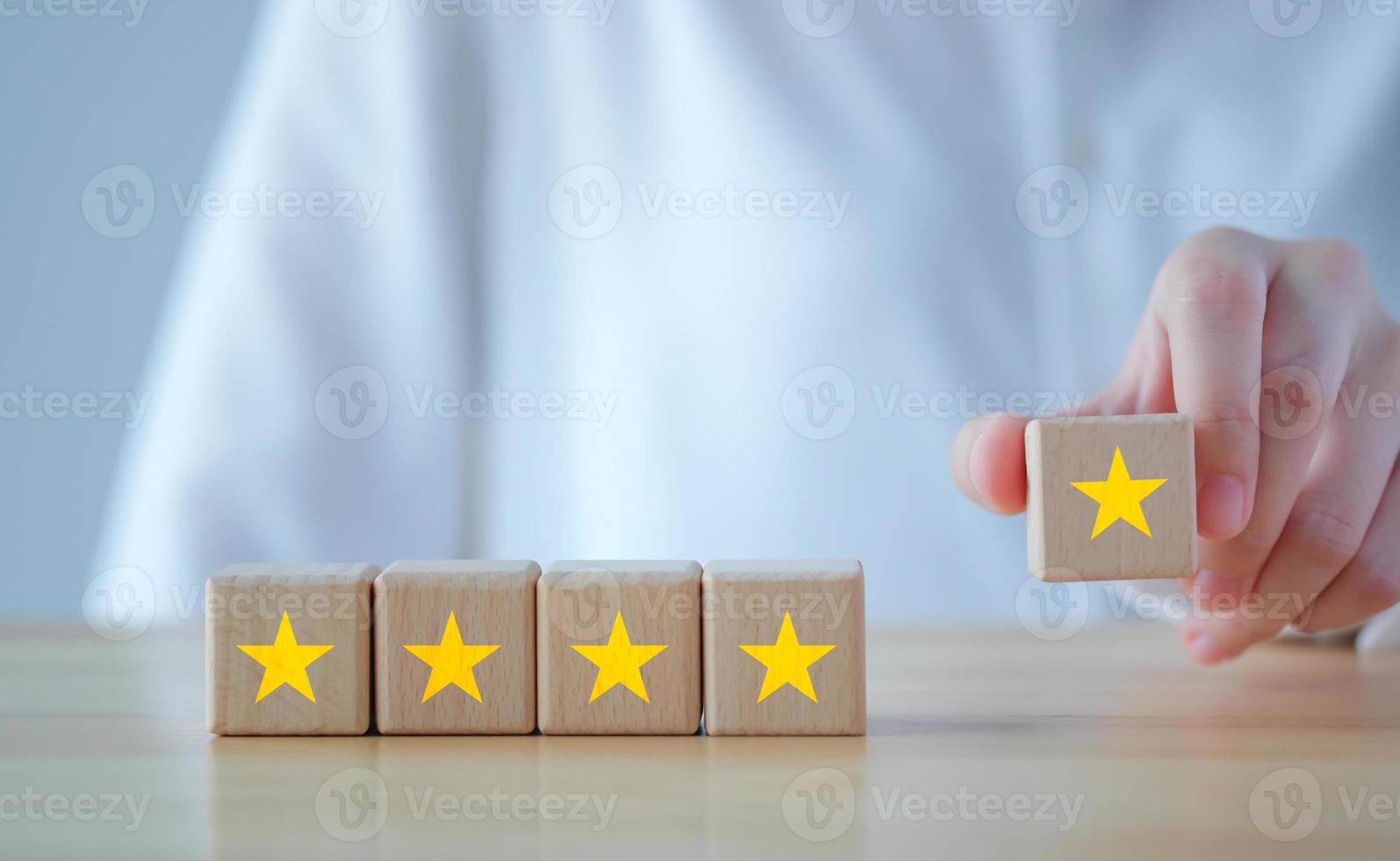 Evaluation, Satisfaction, Feedback, Review concept. Hand holding star to complete five star on wooden block to increase rating. The best excellent business services rating customer experience. photo