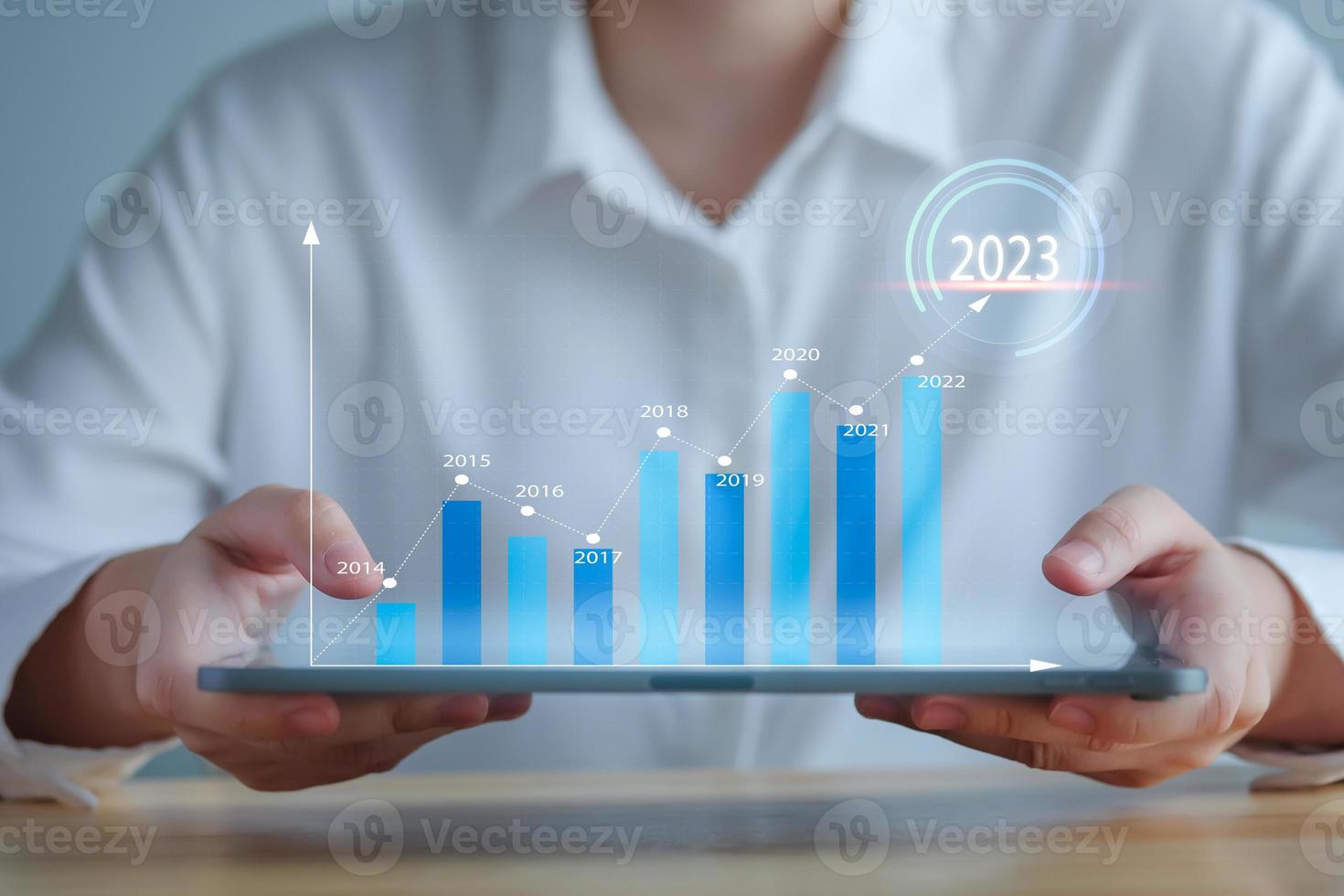 2023 goal and target. Hand holding tablet that showing a growing graph trader or virtual hologram stock. Set strategy and plan for future. Business management and financial concept. photo