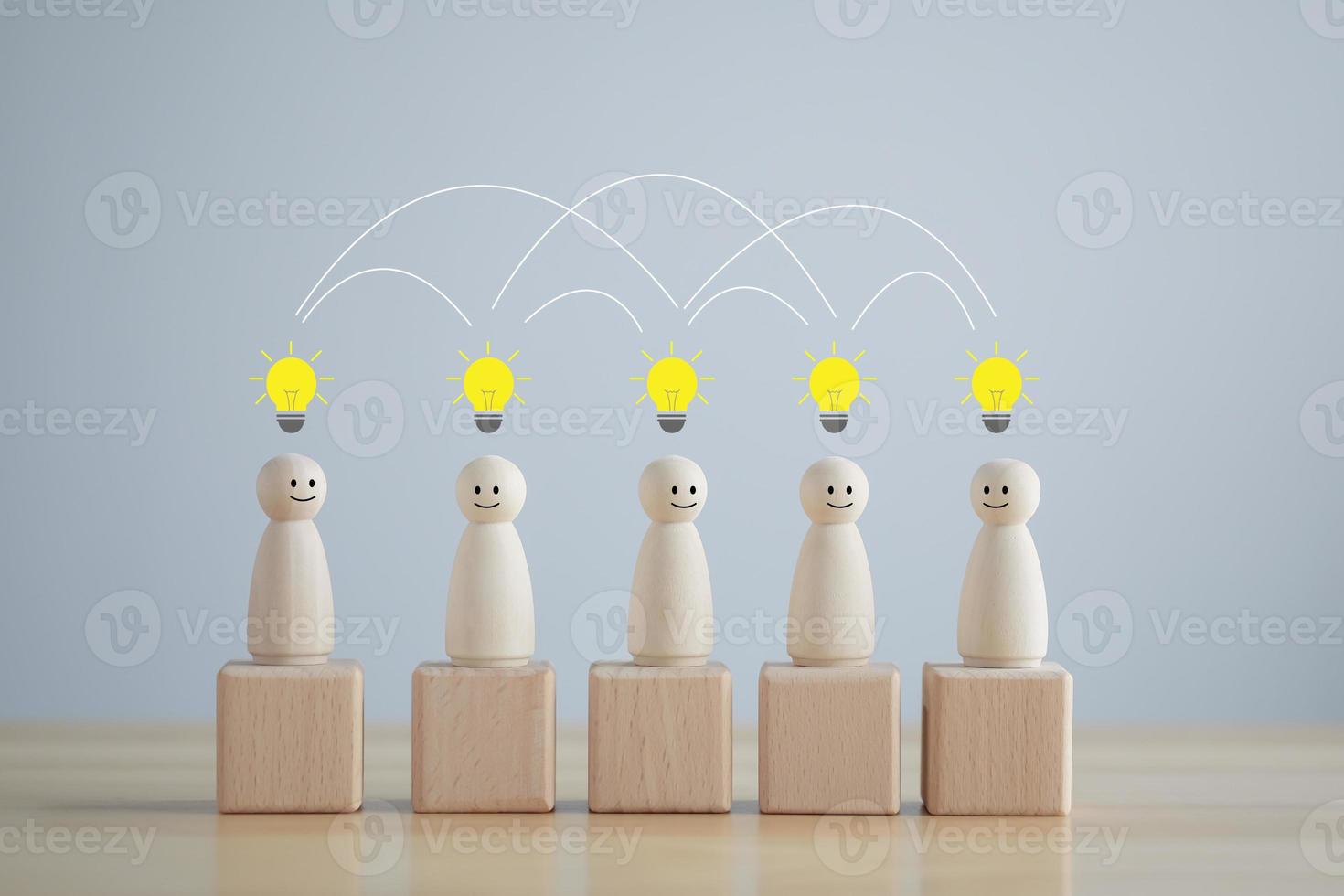 Idea. Teamwork. Happy wooden person figure standing with team and they have light bulb symbol for create and share  idea for team. Social connections. Leader and leadership, coordination. Creativity. photo