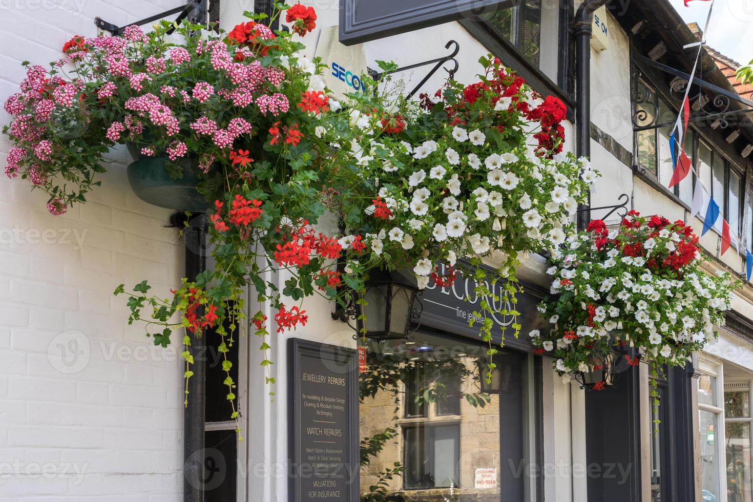 East Grinstead, West Sussex, UK, 2014. Hanging baskets outside a shop in East Grinstead photo