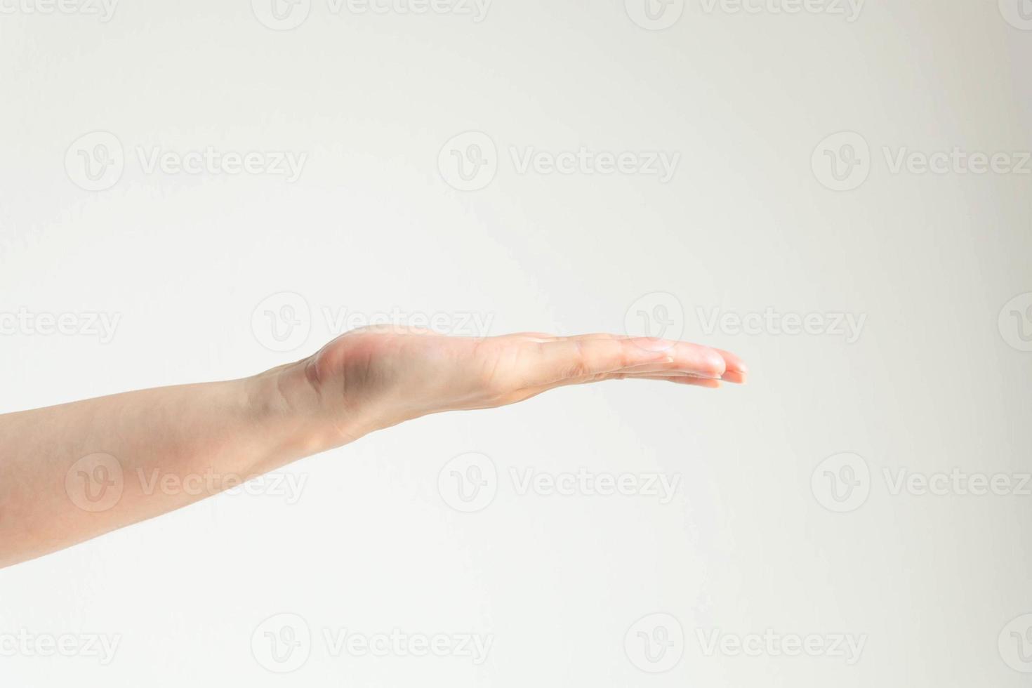 mujer abre la palma de la mano sobre fondo blanco. foto