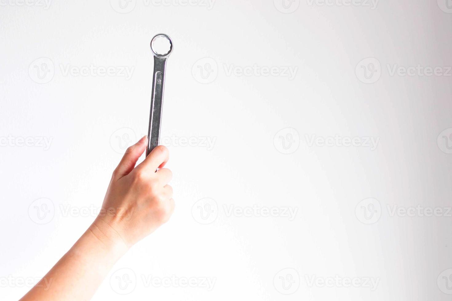 hand holding a ring spanner on white background photo