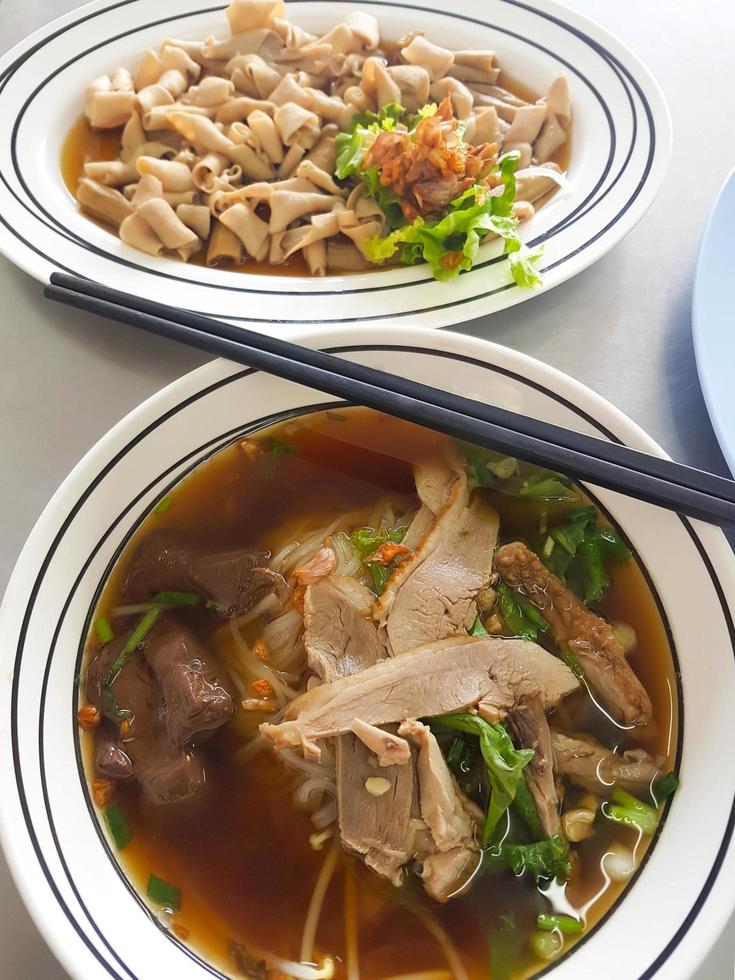 Top view of duck noodles in brown soup and boiled duck intestine. photo