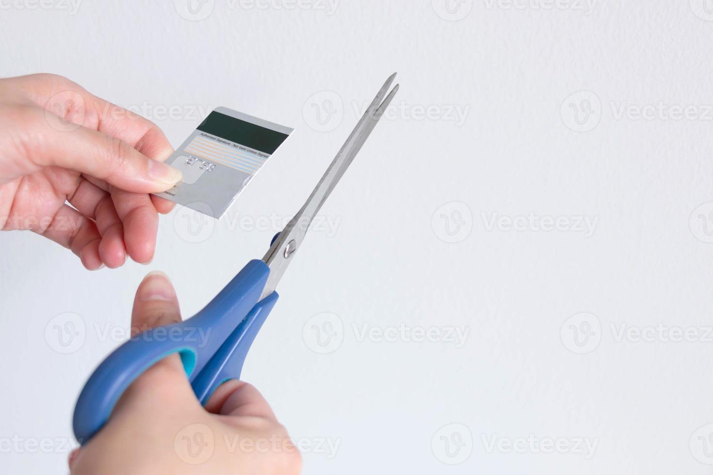 A woman cutting a credit card with scissors for stop making debt from it. photo