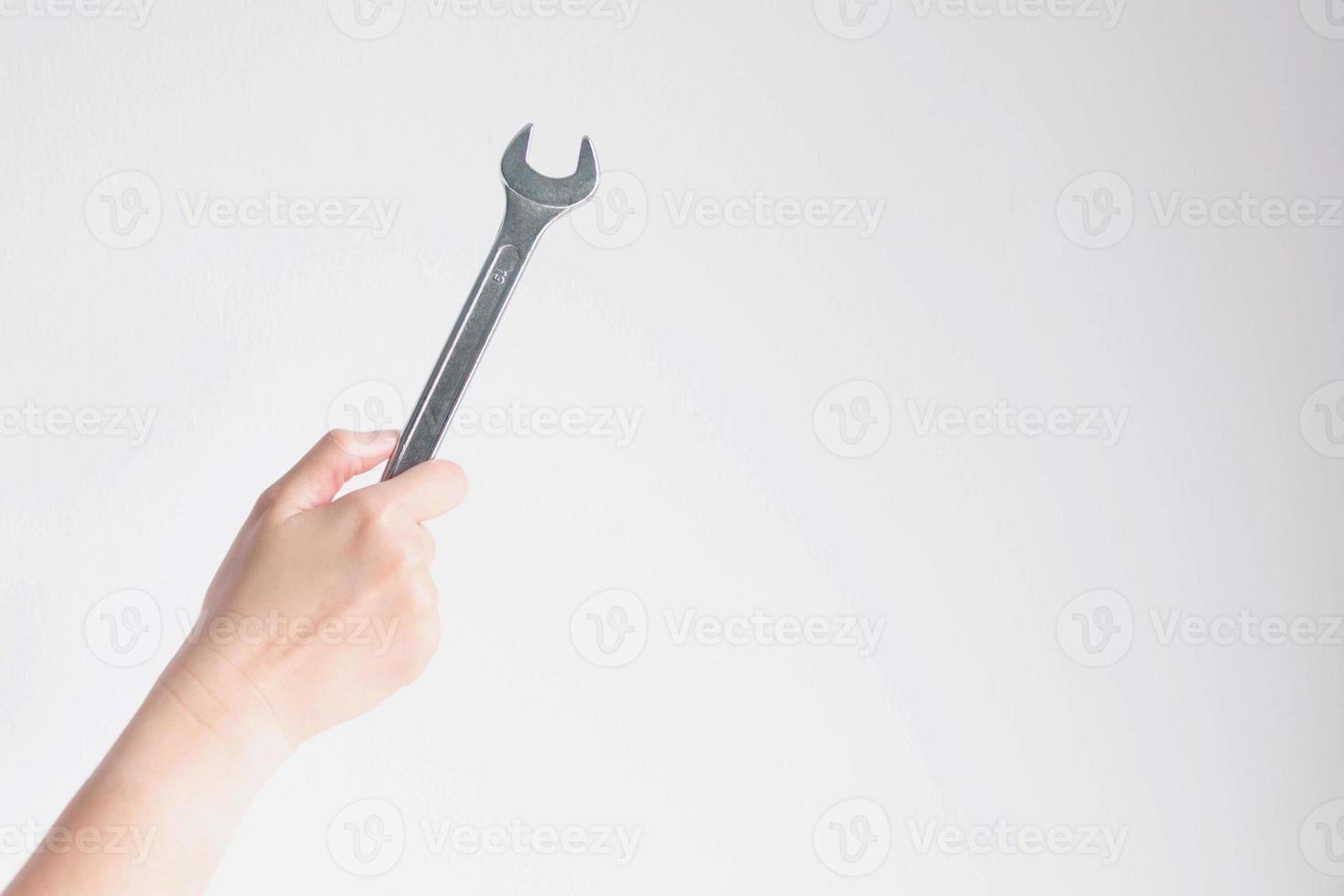 hand holding a wrench on white background. photo