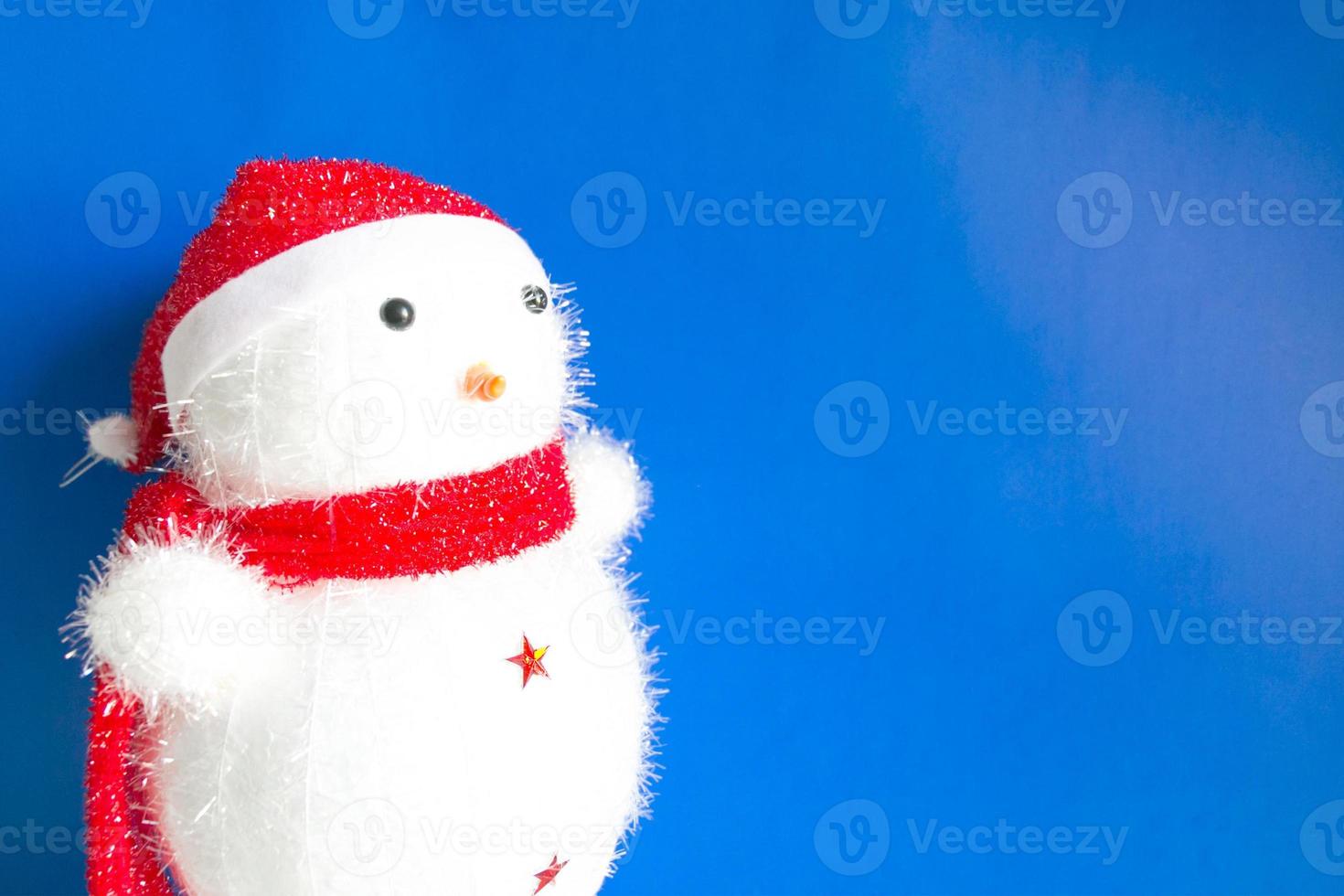 fondo navideño de muñeco de nieve con sombrero rojo y bufanda roja. foto
