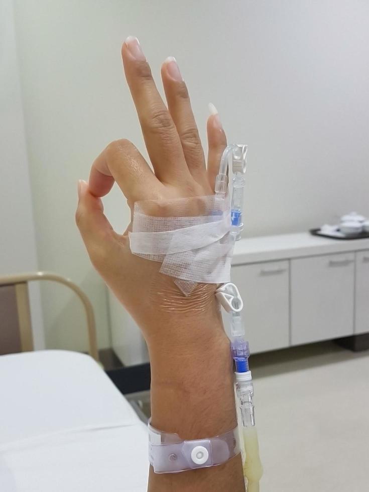 primer plano de la mano del paciente que muestra el símbolo ok, lo que significa que está bien en la habitación del hospital. foto