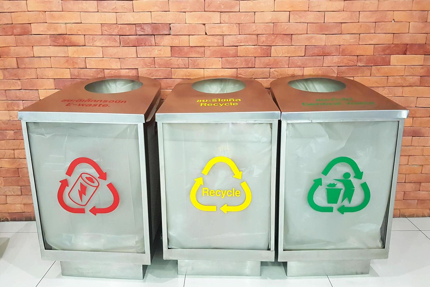 tres contenedores con colores y símbolos separados para cada categoría de basura. foto