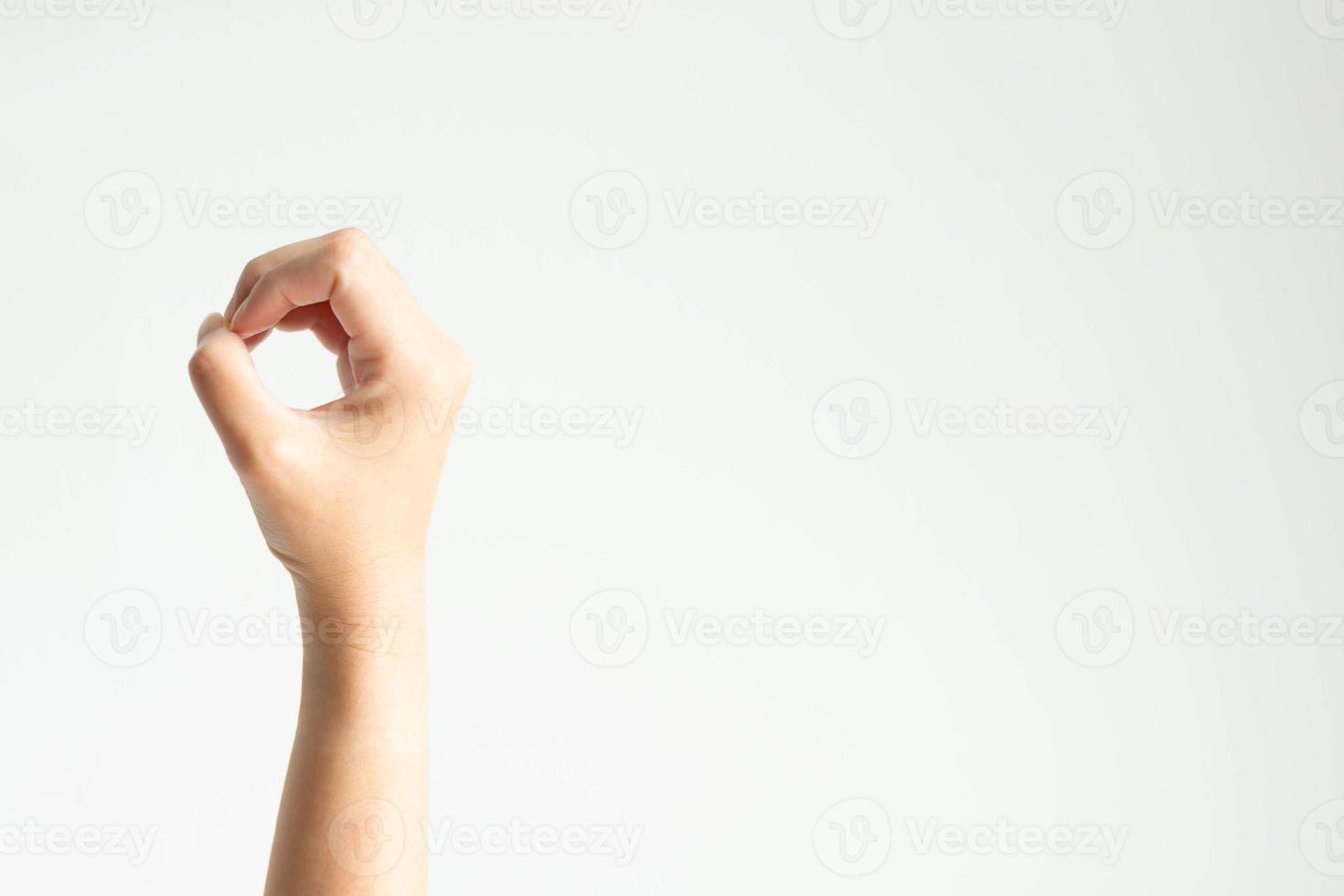 A hand making circle shape, or showing number zero by using thumb touching other fingers on white background. photo