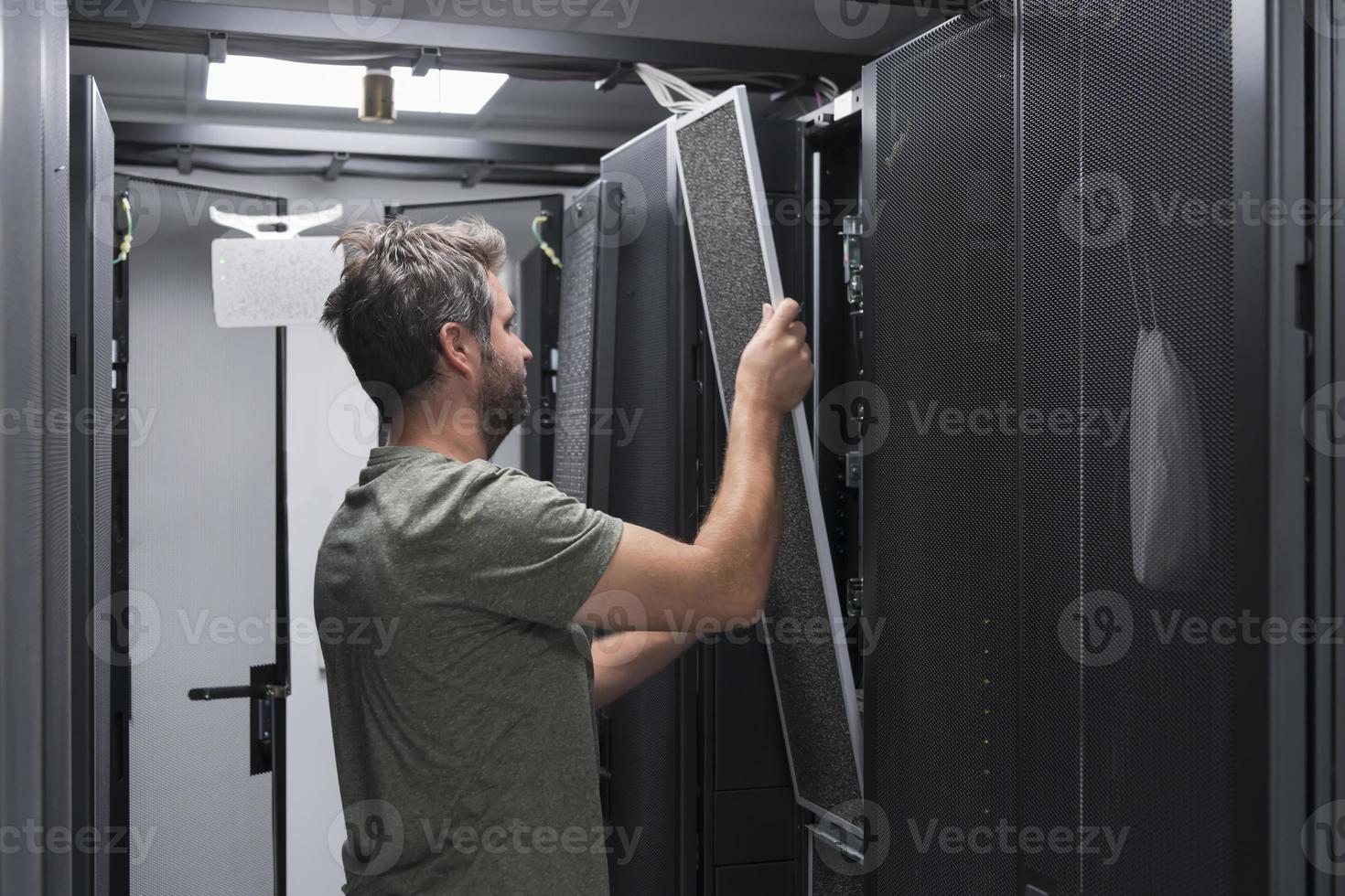 IT engineer working In the server room or data center The technician puts in a rack a new server of corporate business mainframe supercomputer or cryptocurrency mining farm. photo