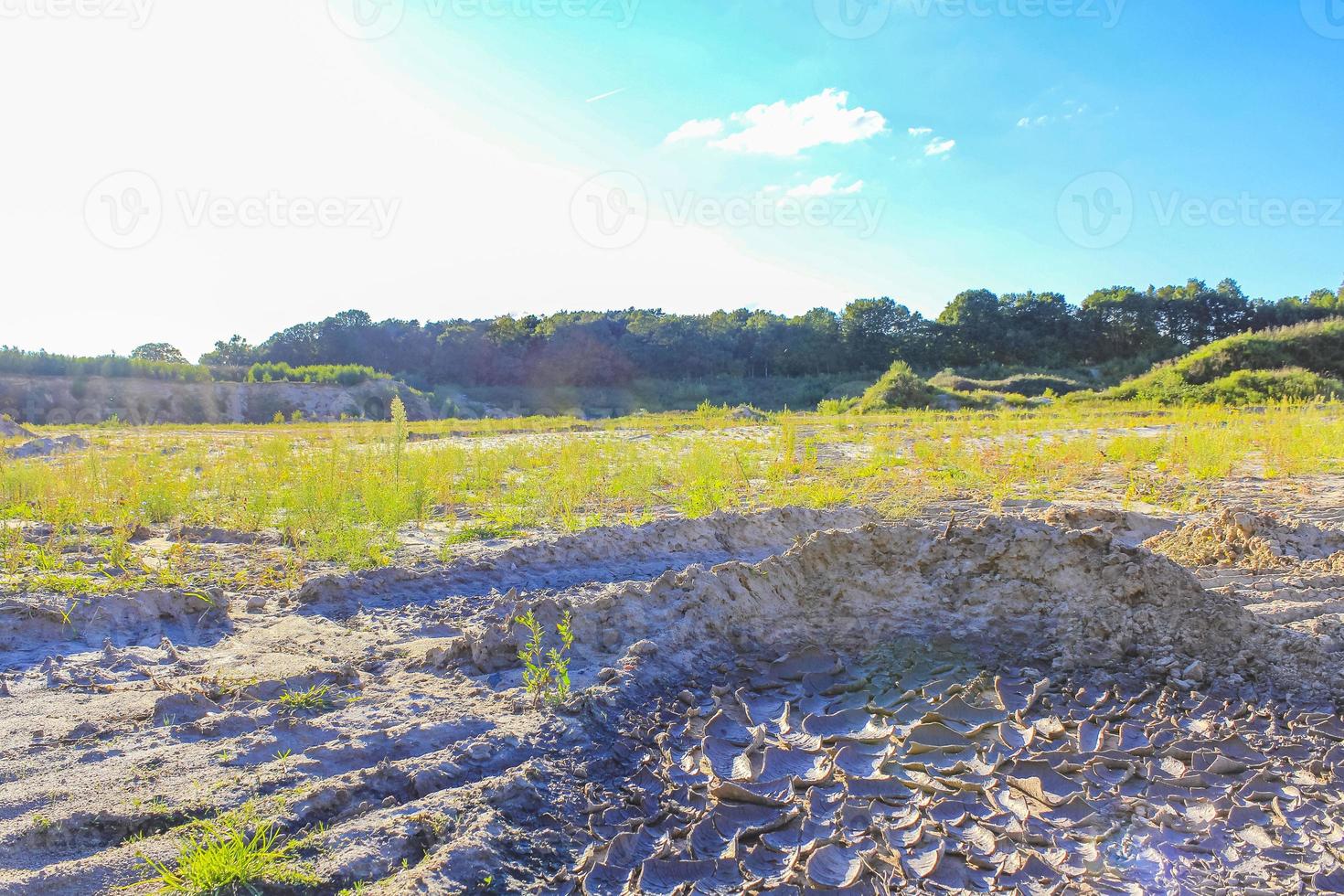 Excavated sand mountains and rubble piles quarry lake dredging pond. photo