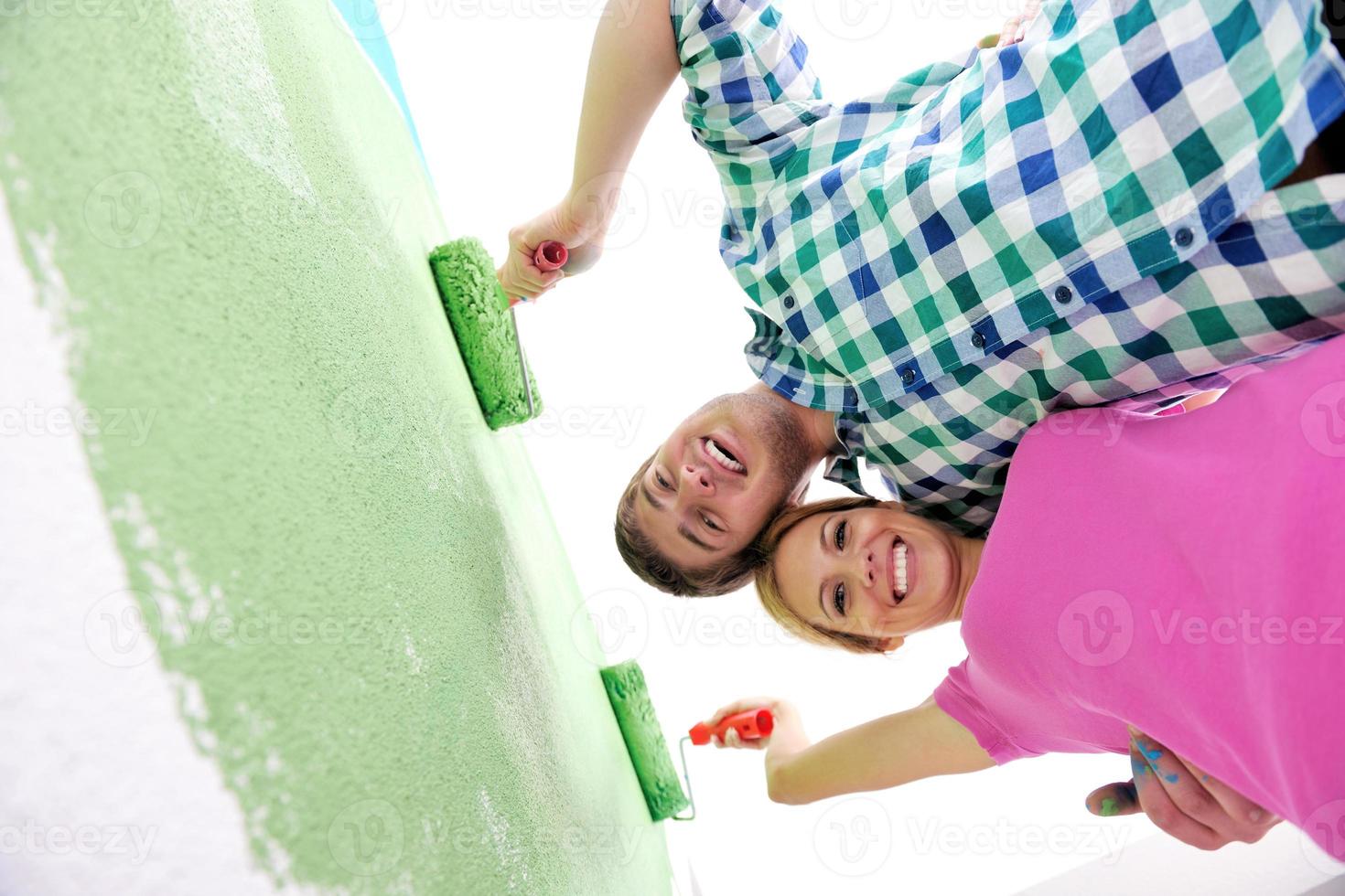 happy couple paint wall at new home photo