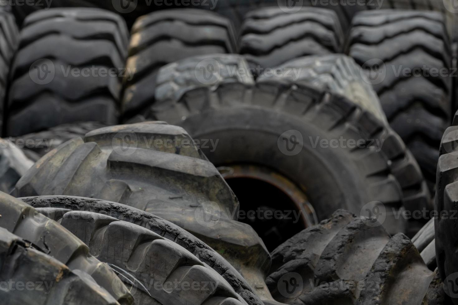 Closeup used truck tires. Old tyres waste for recycle or for landfill. Black rubber tire of truck. Pile of used tires at recycling yard. Material for landfill. Recycled tires. disposal waste tires. photo