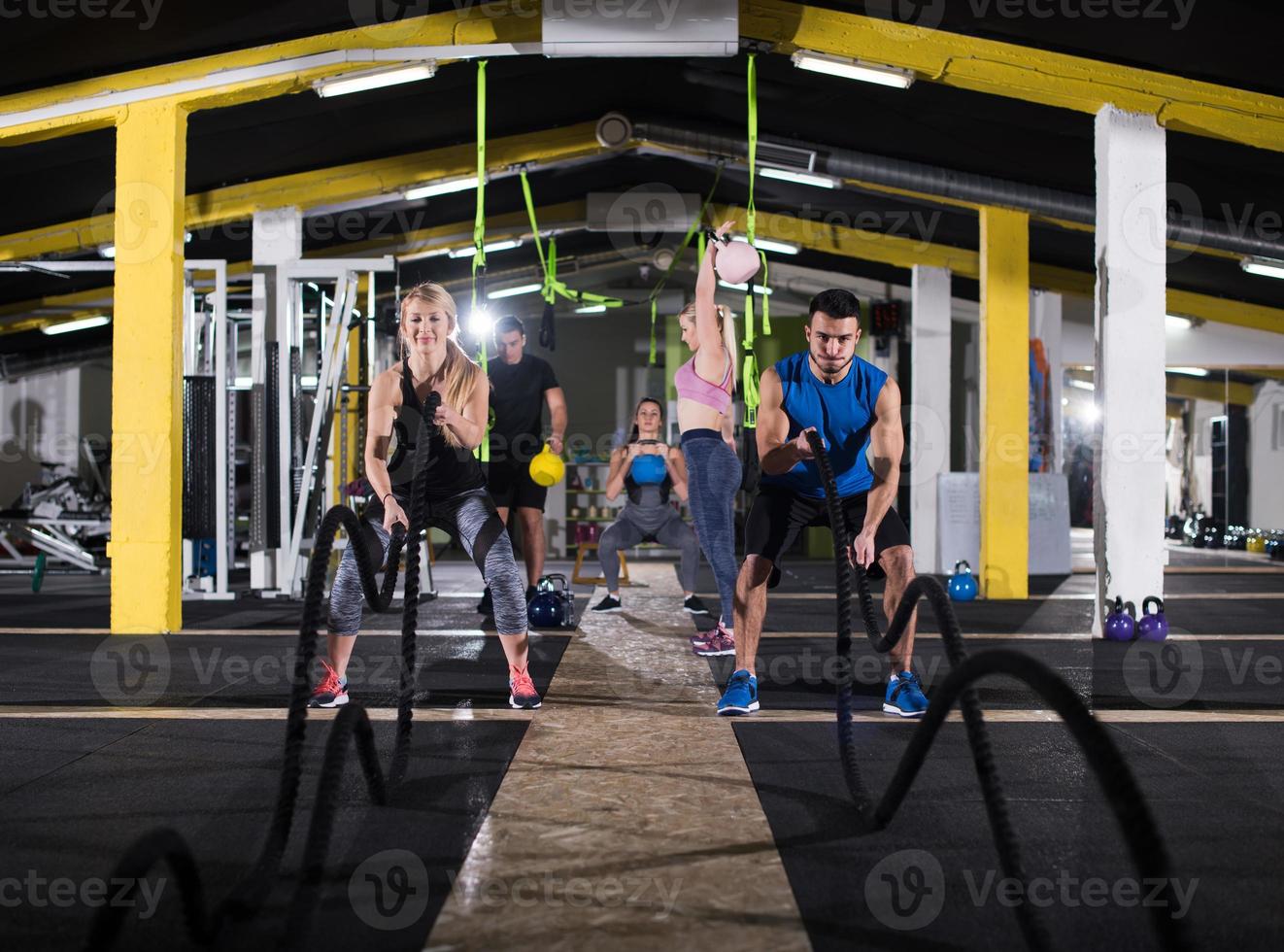 sports couple doing battle ropes cross fitness exercise photo