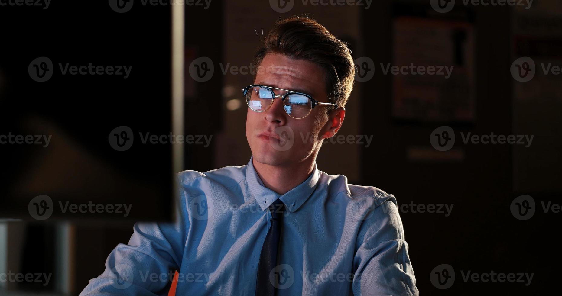 man working on computer in dark office photo