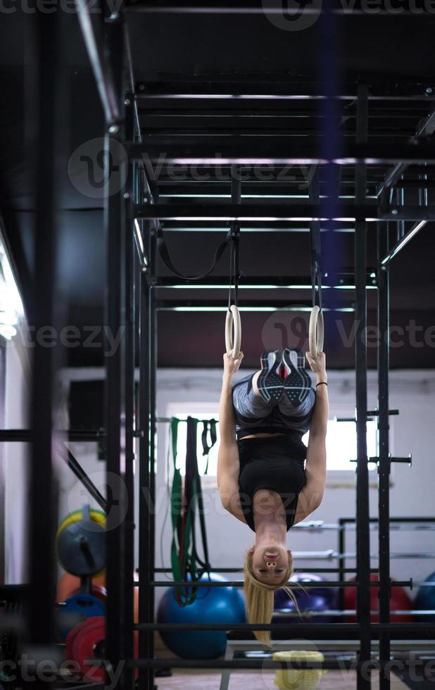 mujer trabajando en anillos de gimnasia foto