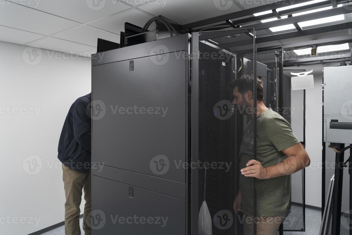 Technicians team updating hardware inspecting system performance in super computer server room or cryptocurrency mining farm. photo