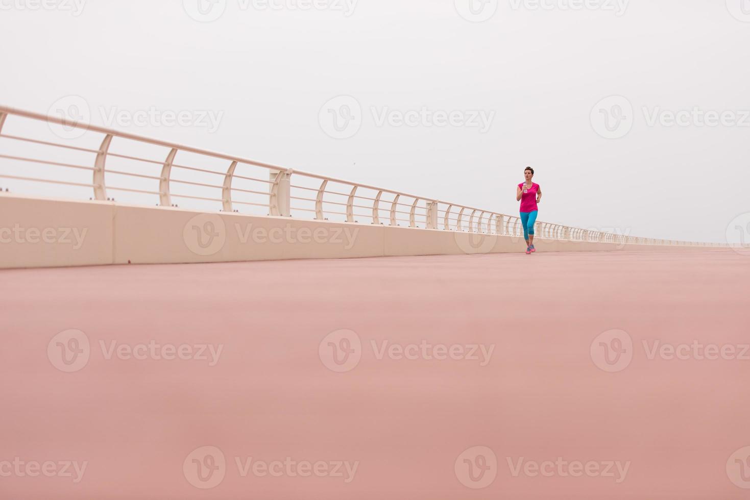 woman busy running on the promenade photo