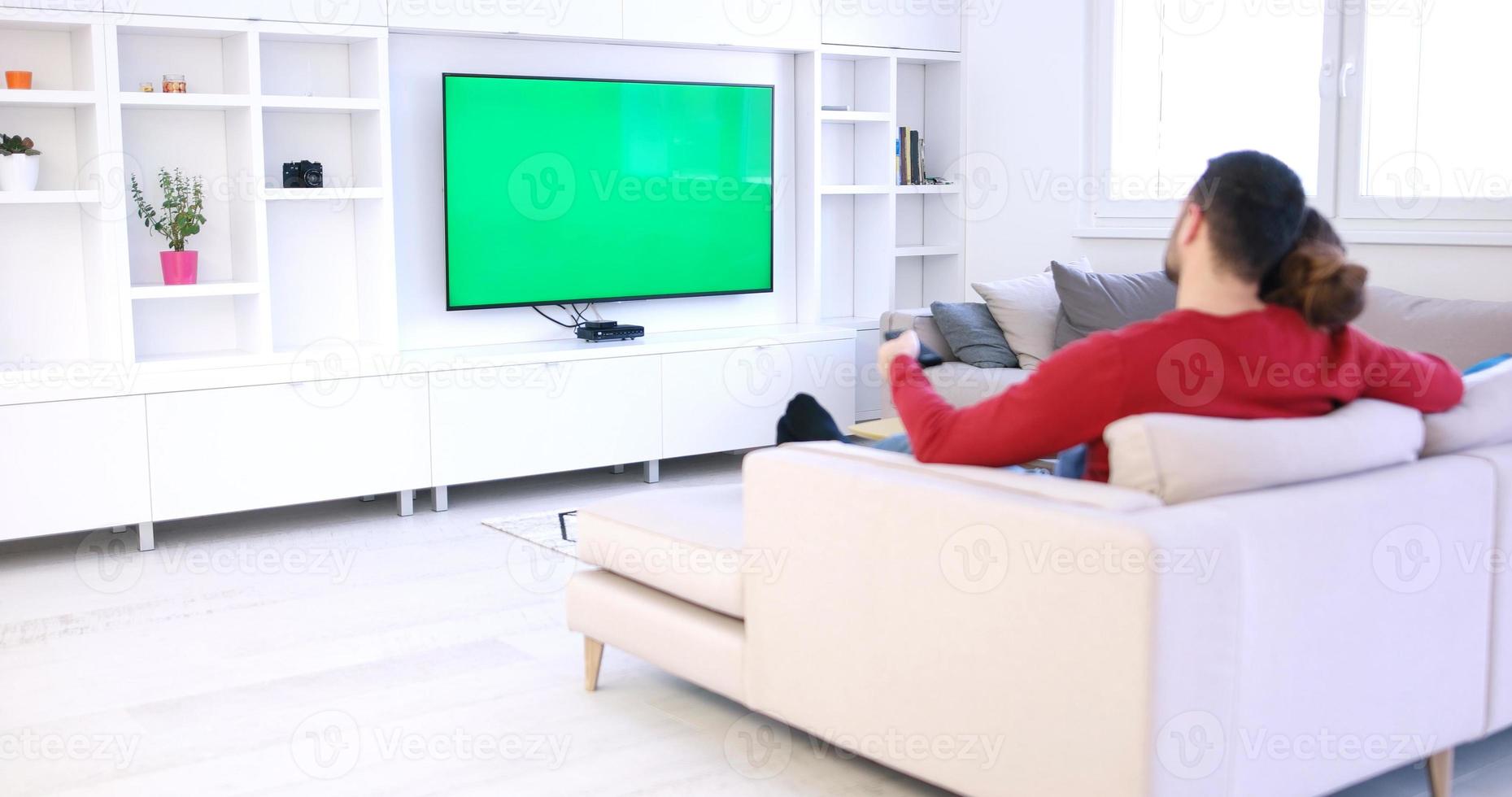 Young couple on the sofa watching television photo