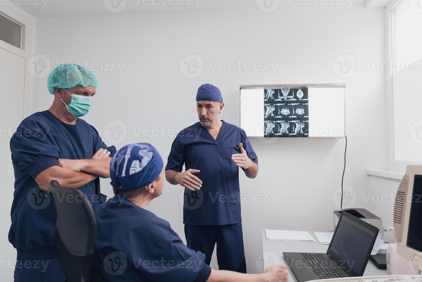 Orthopedist doctor team examining digital X-ray picture in clinic or hospital photo