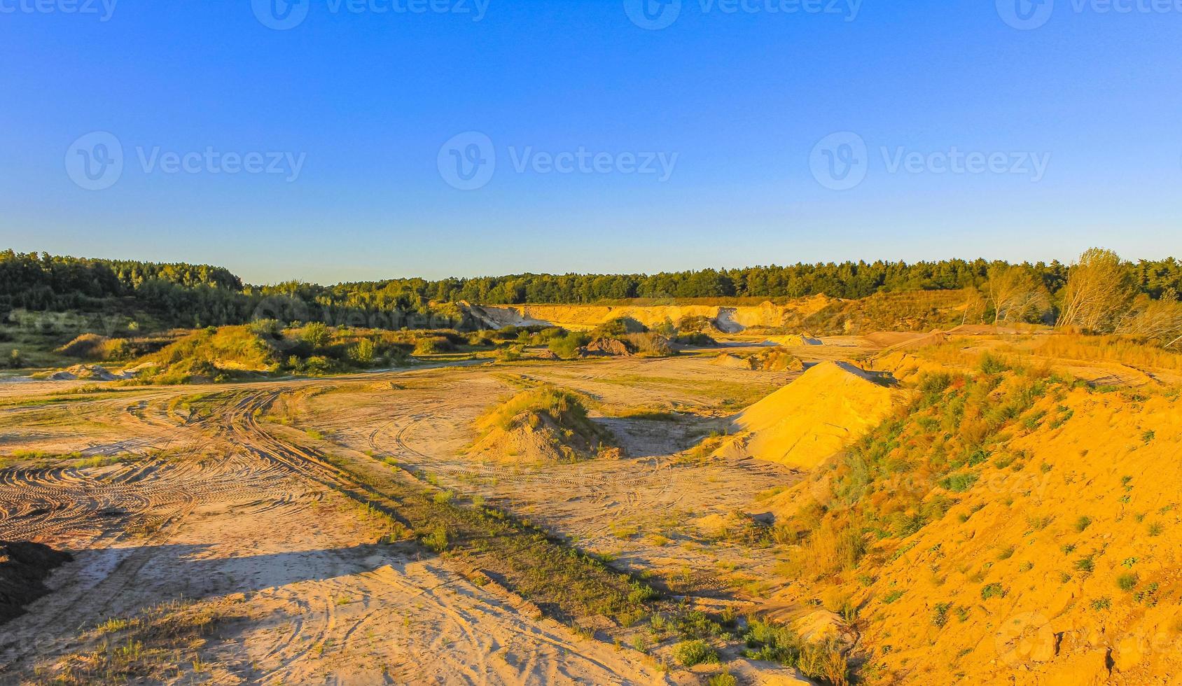 montañas de arena excavadas y pilas de escombros lago de cantera estanque de dragado. foto