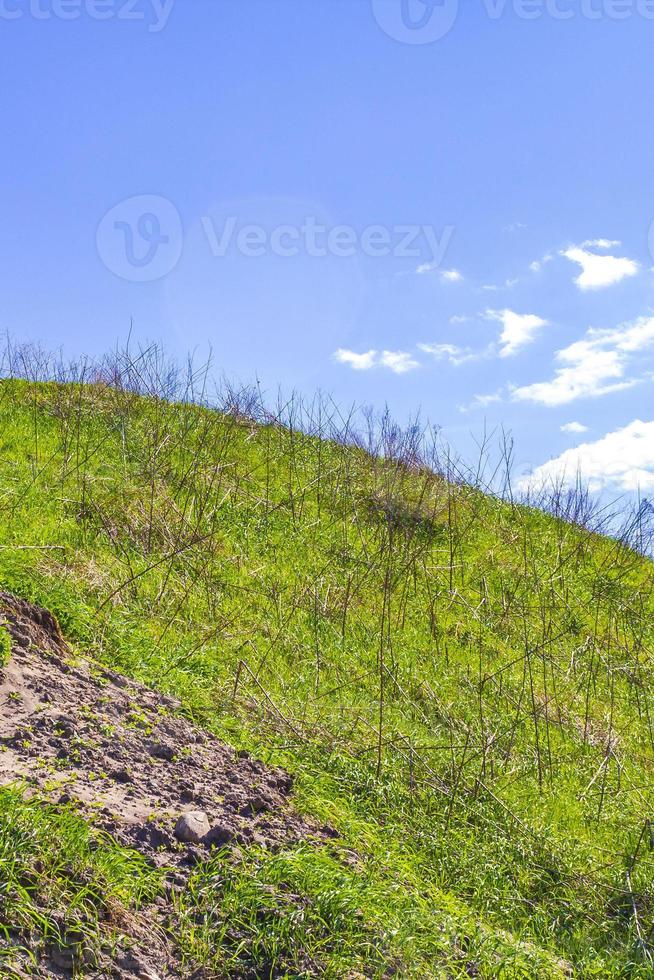 Excavated sand mountains and rubble piles quarry lake dredging pond. photo